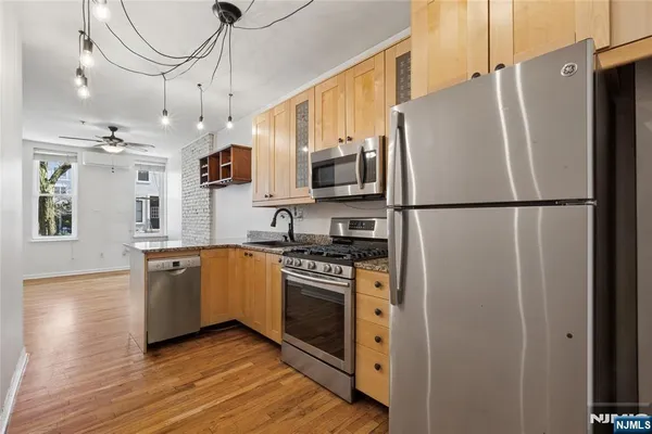 a kitchen with stainless steel appliances a refrigerator sink and microwave