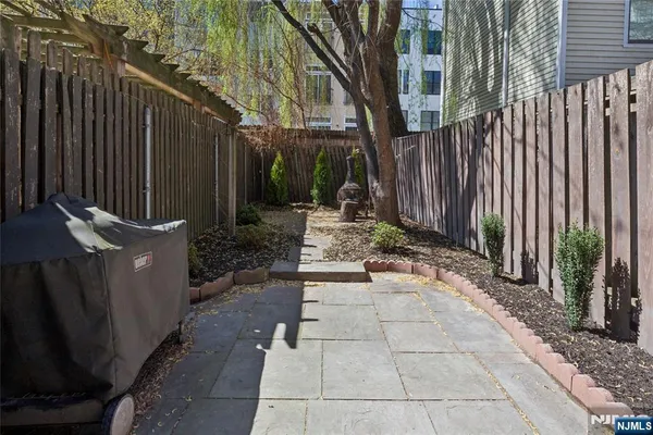 a view of a backyard with plants and wooden fence