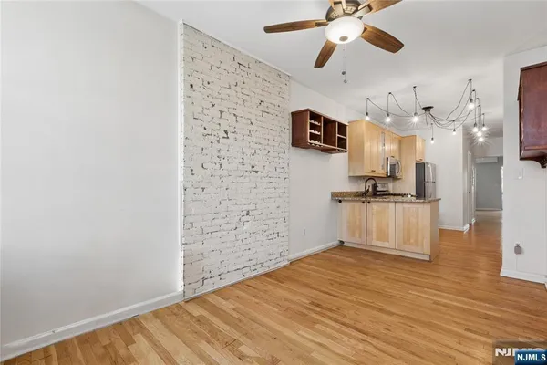 a view of empty room with wooden floor and ceiling fan