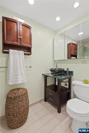a bathroom with a toilet a sink and mirror