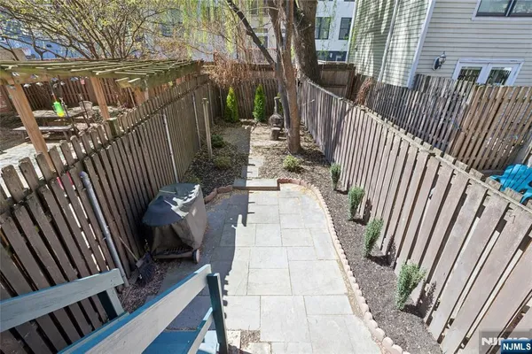 a backyard of a house with barbeque oven and glass table