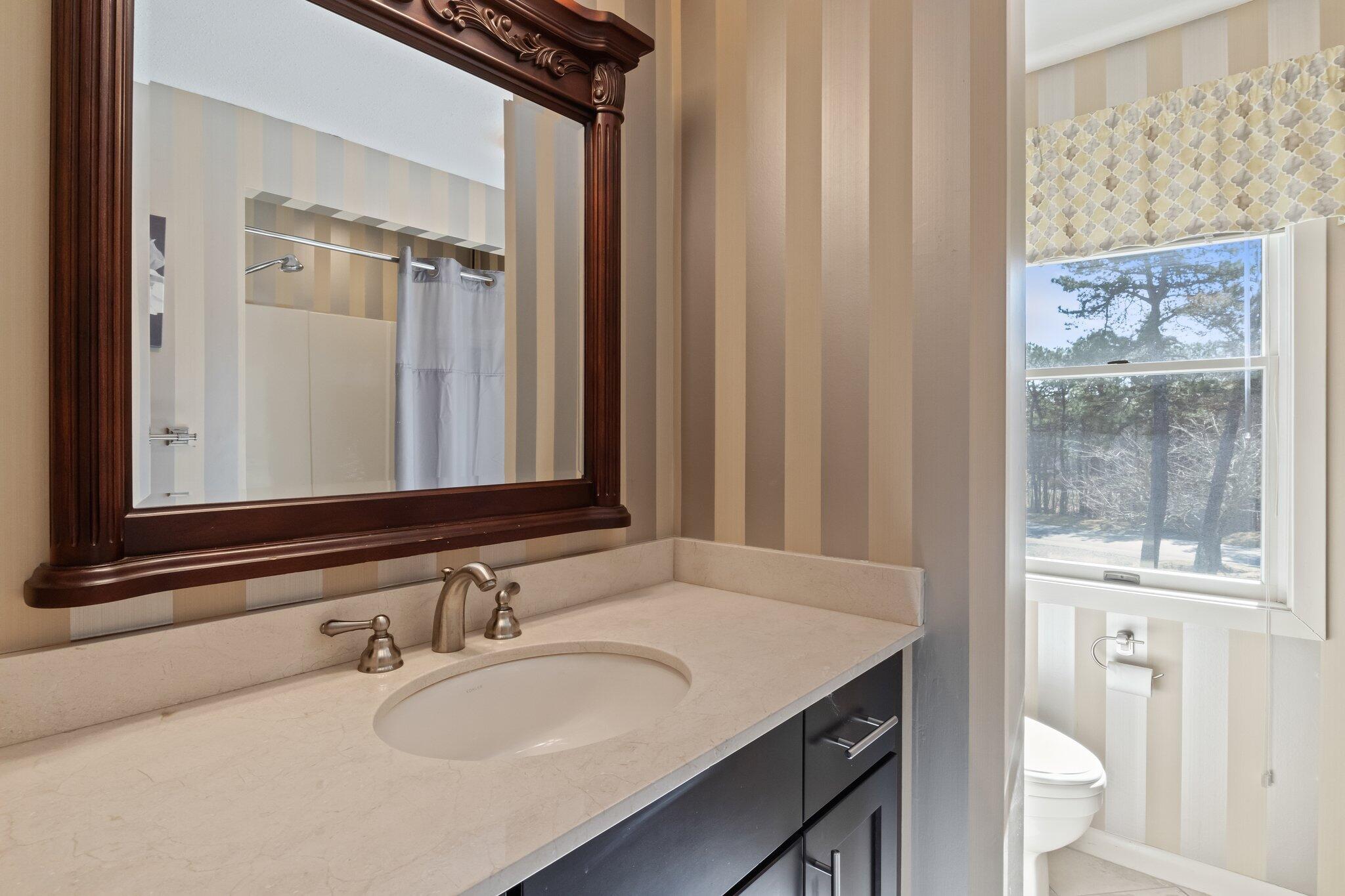 91 Shellback Way, Unit N Mashpee, MA 02649 - Photo 24 of 40 a bathroom with a granite countertop sink and a mirror
