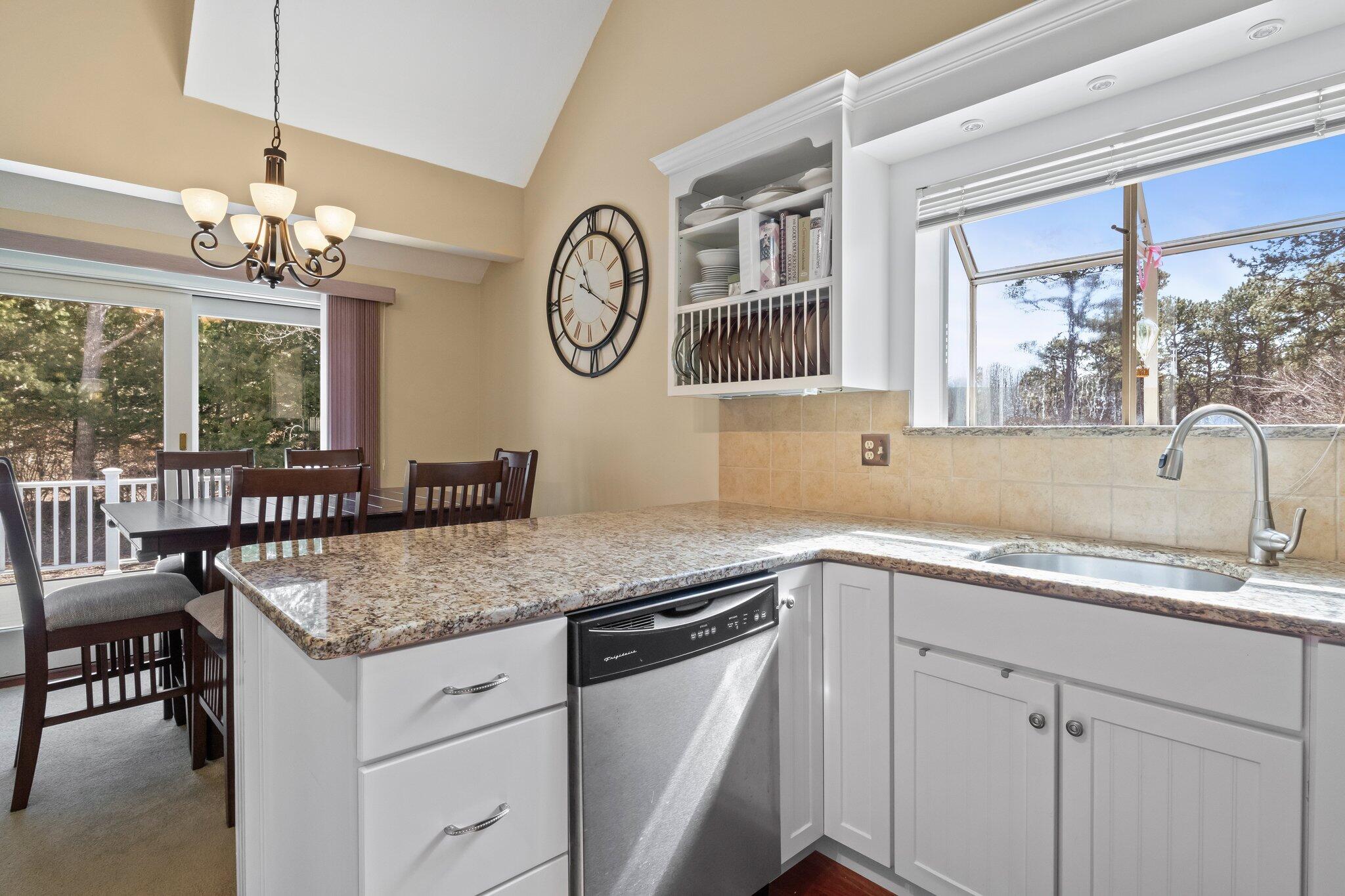 91 Shellback Way, Unit N Mashpee, MA 02649 - Photo 4 of 40 a kitchen with a sink a large window cabinets and chairs