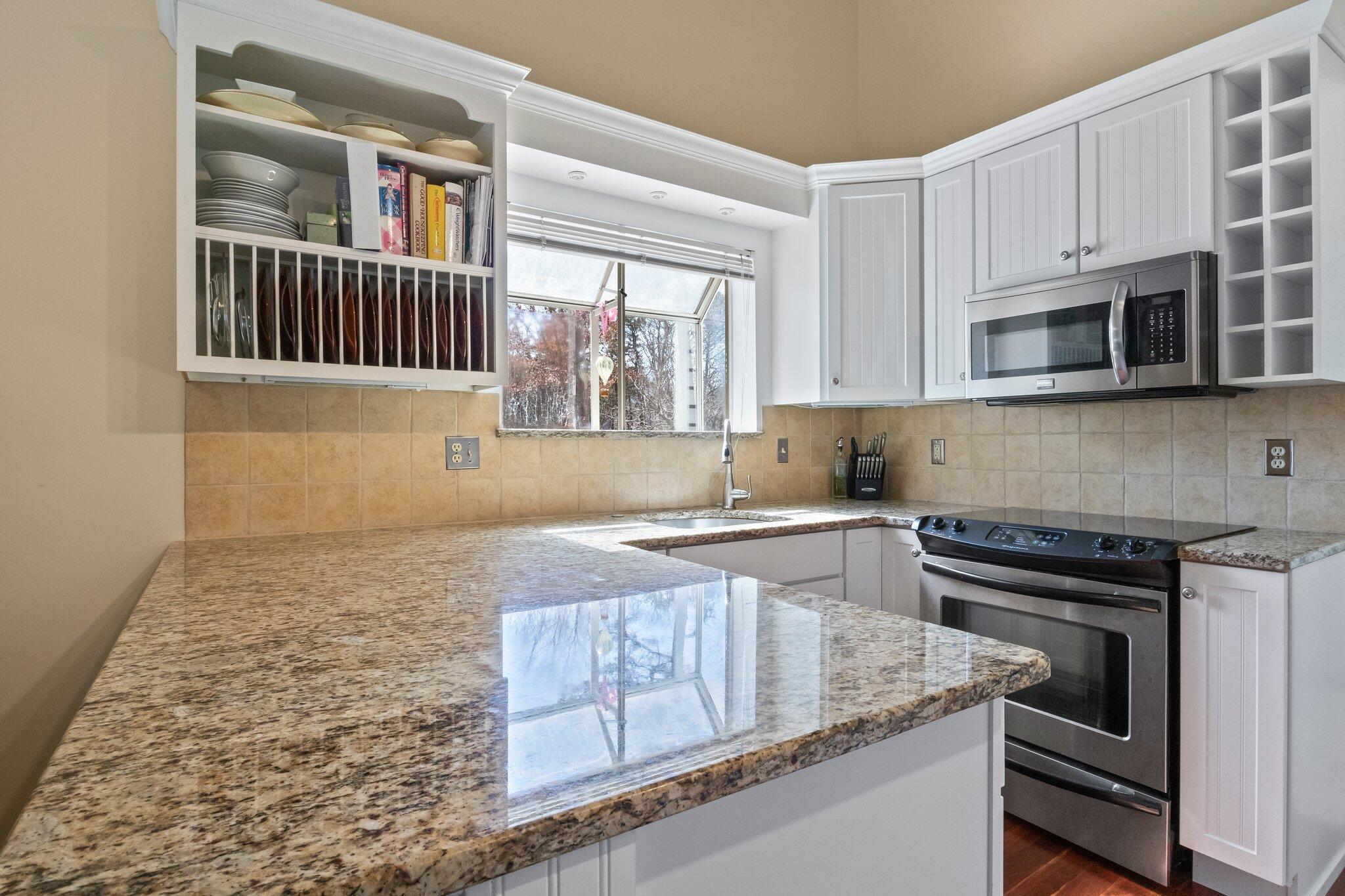 91 Shellback Way, Unit N Mashpee, MA 02649 - Photo 5 of 40 a kitchen with granite countertop a stove sink and microwave