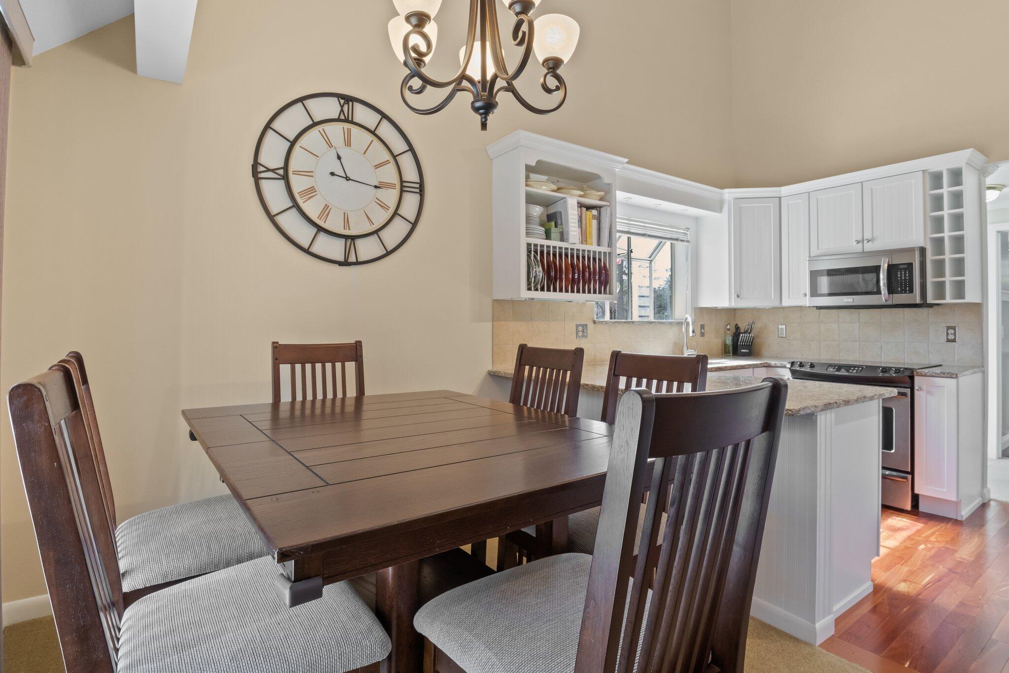 91 Shellback Way, Unit N Mashpee, MA 02649 - Photo 7 of 40 a view of a dining room with furniture a kitchen and chandelier
