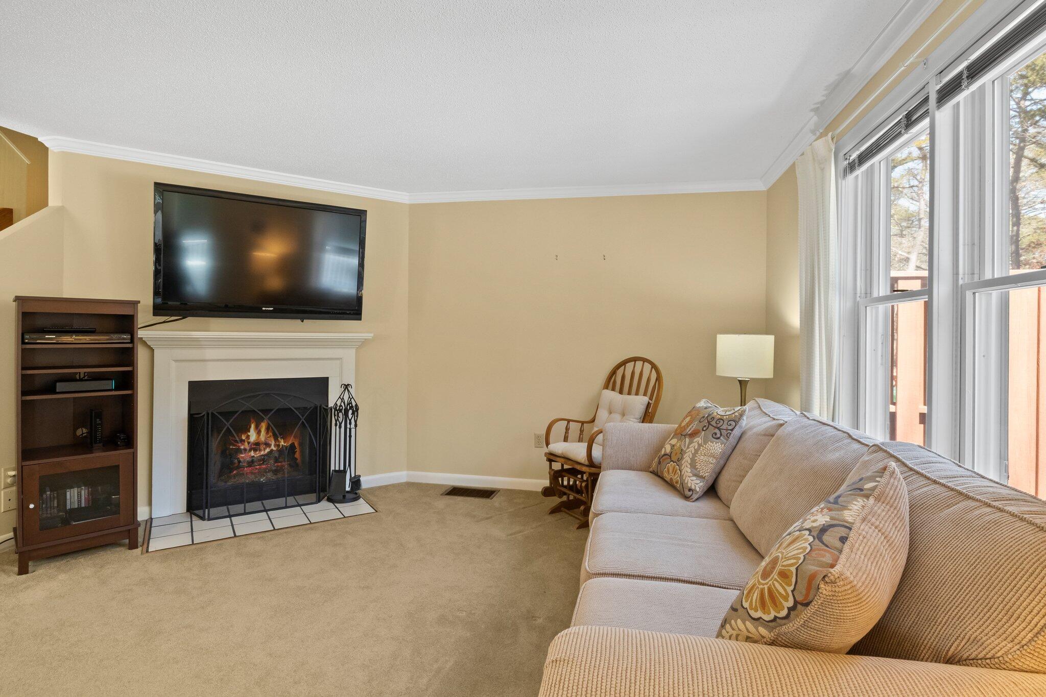 91 Shellback Way, Unit N Mashpee, MA 02649 - Photo 10 of 40 a living room with furniture a flat screen tv and a fireplace