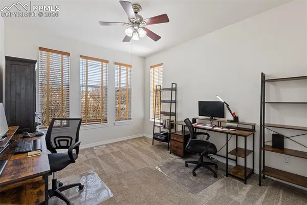 a view of a workspace with furniture and a window