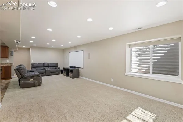 a living room with furniture a window and a flat screen tv