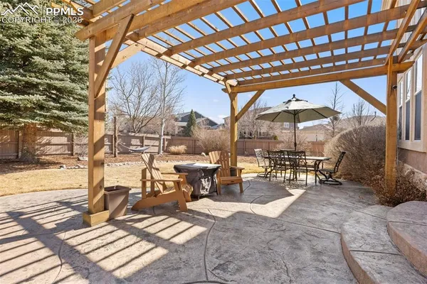 a view of backyard with wooden fence and large trees