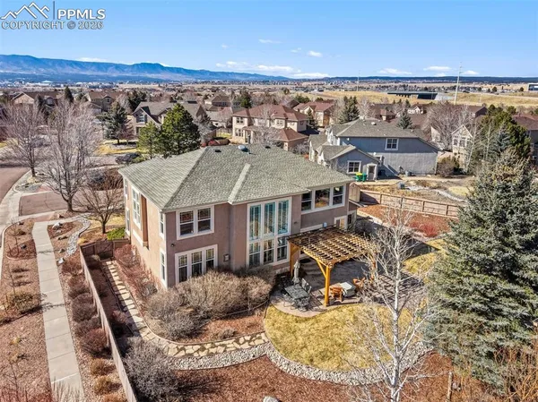 an aerial view of a house with a mountain