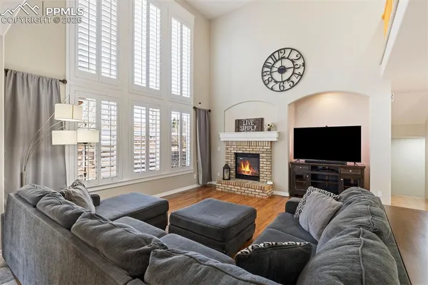a living room with furniture a flat screen tv and a fireplace