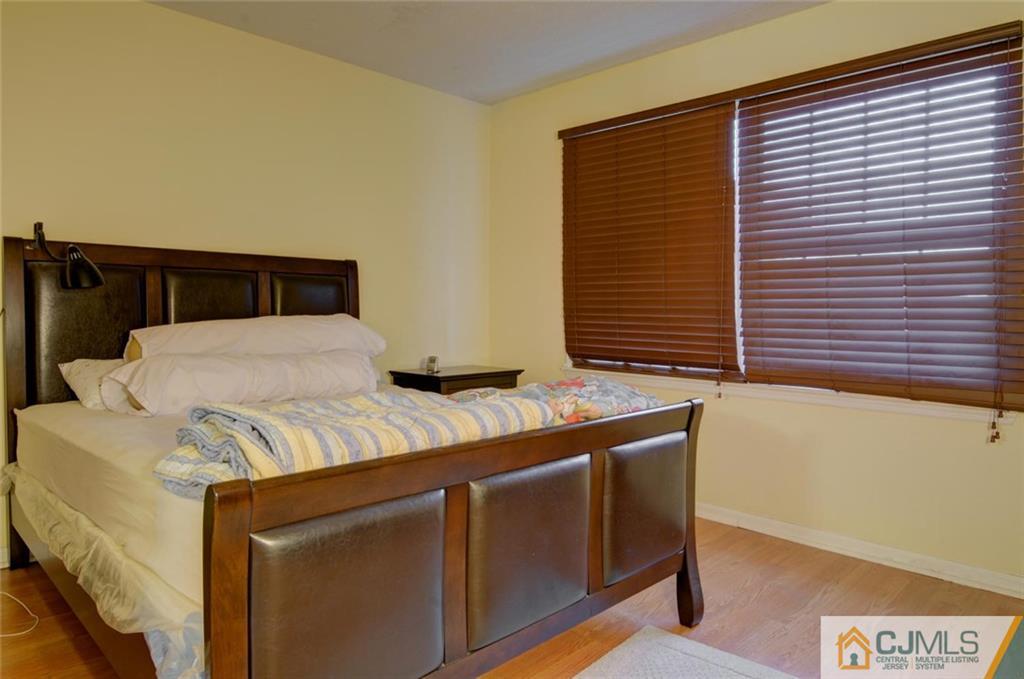 512 Edpas Road, Unit 512 New Brunswick, NJ 08901 - Photo 11 of 19 a bed sitting in a bedroom next to a window