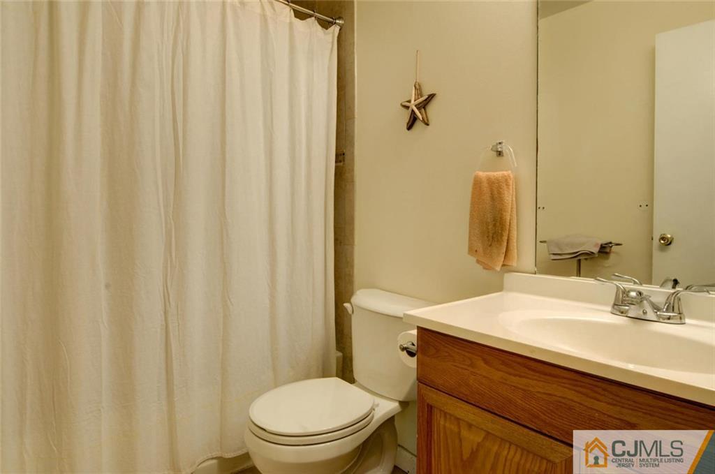 512 Edpas Road, Unit 512 New Brunswick, NJ 08901 - Photo 12 of 19 a bathroom with a sink a toilet and shower curtain