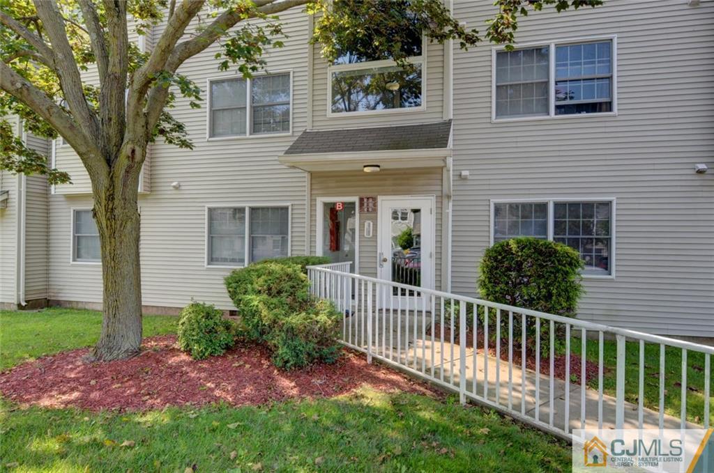512 Edpas Road, Unit 512 New Brunswick, NJ 08901 - Photo 16 of 19 a view of a house with a small yard and a large tree with wooden fence