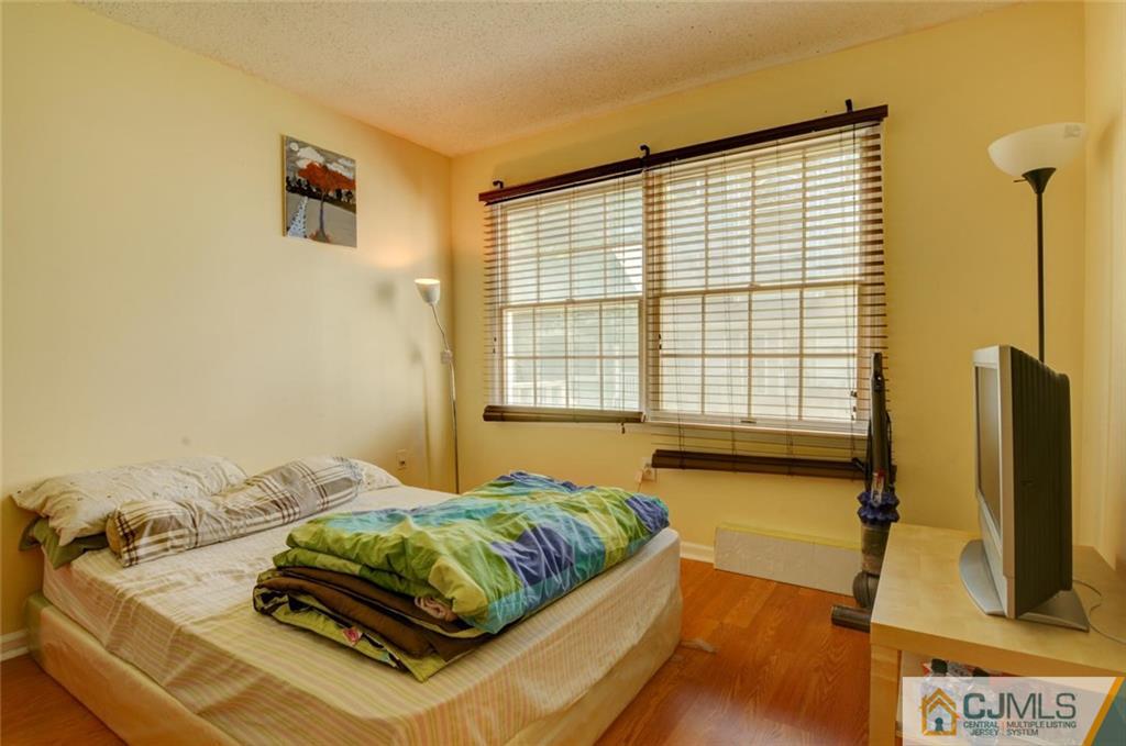 512 Edpas Road, Unit 512 New Brunswick, NJ 08901 - Photo 9 of 19 a bedroom with a bed and flat screen tv