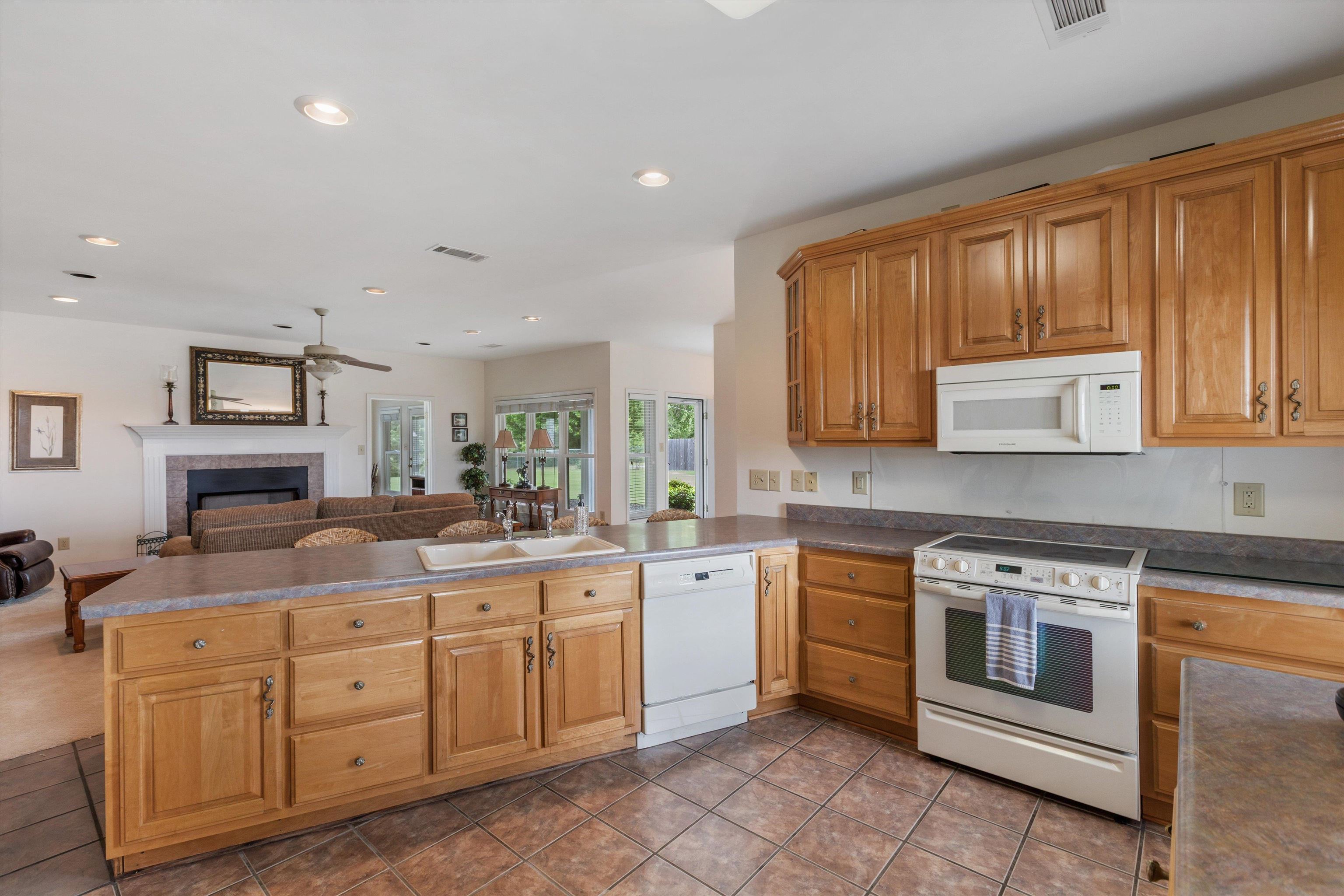 2225 Candy Lane Burlison, TN 38015 - Photo 8 of 27 Kitchen featuring light wood cabinetry, white appliances, and a double basin sink