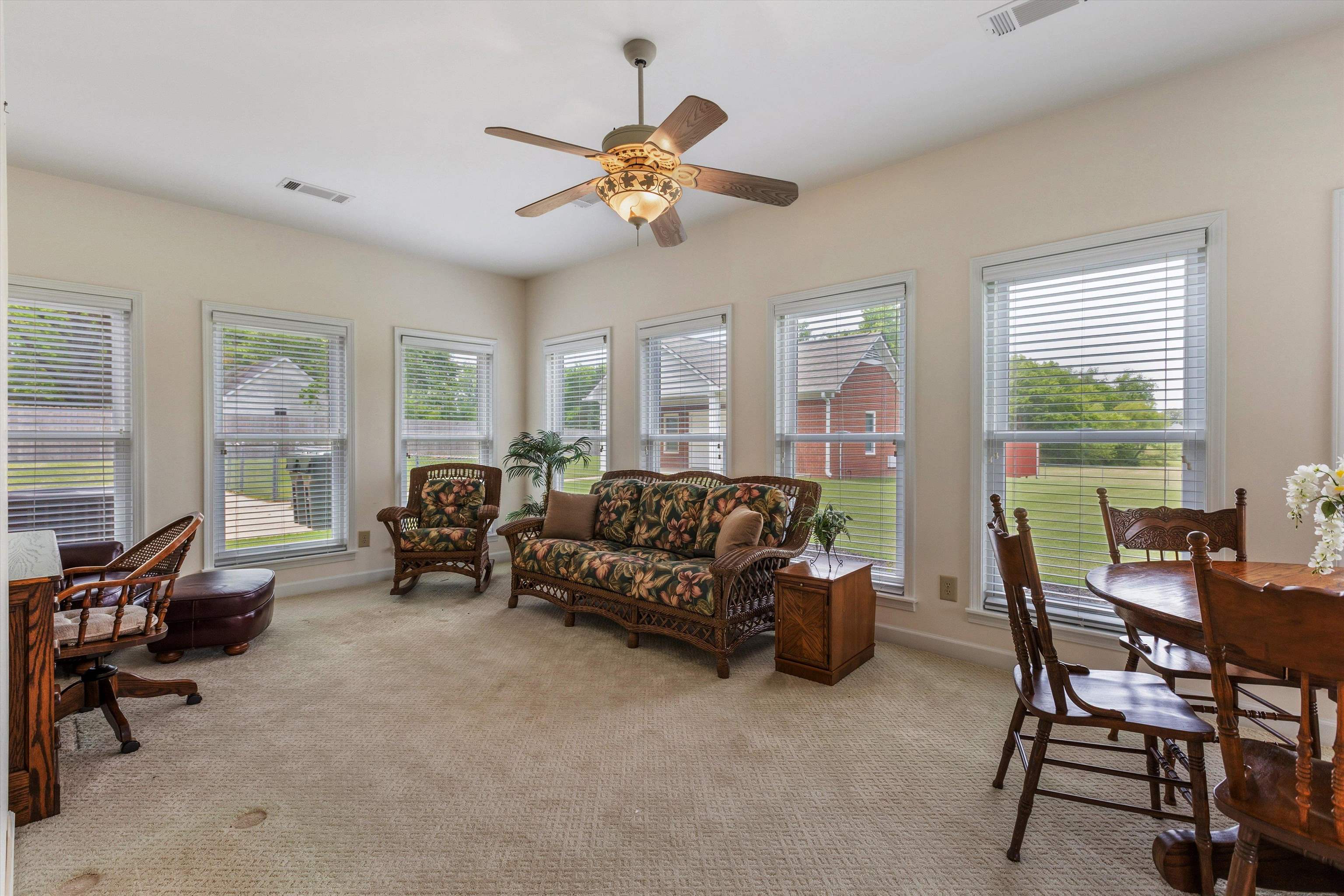 2225 Candy Lane Burlison, TN 38015 - Photo 10 of 27 Sunlit room featuring multiple windows with blinds, a ceiling fan with integrated lighting, and neutral-toned carpeting