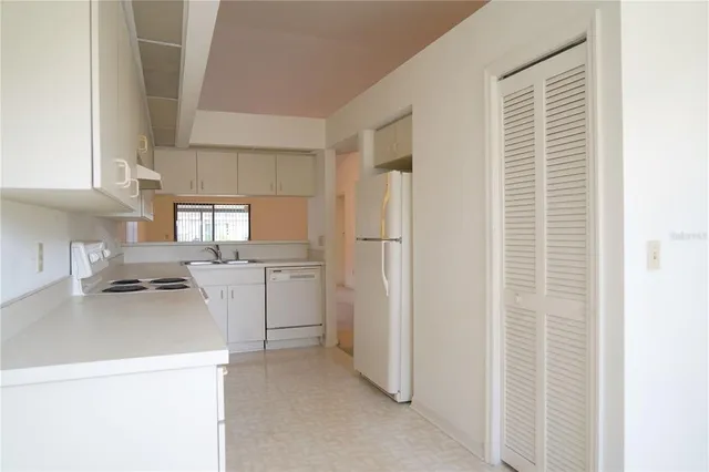 a kitchen with a refrigerator a stove top oven and cabinets