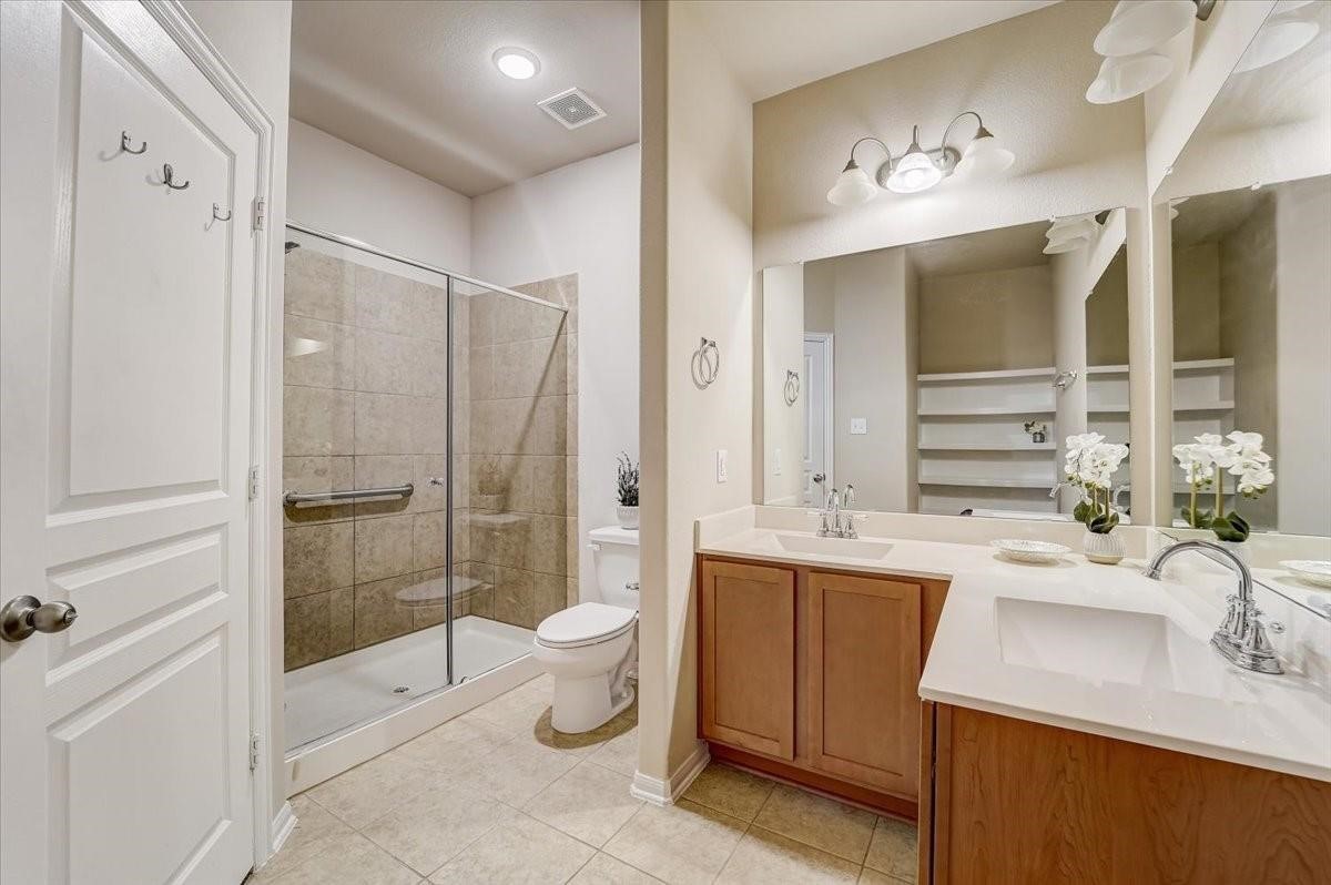 8827 Willet Street Baytown, TX 77521 - Photo 12 of 18 a bathroom with a double vanity sink toilet and shower