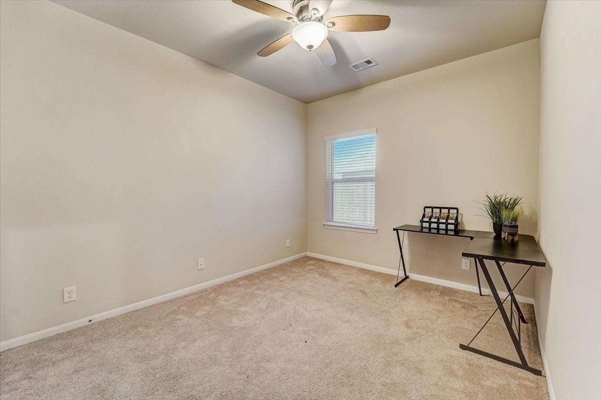 8827 Willet Street Baytown, TX 77521 - Photo 16 of 18 an empty room with a window and a ceiling fan