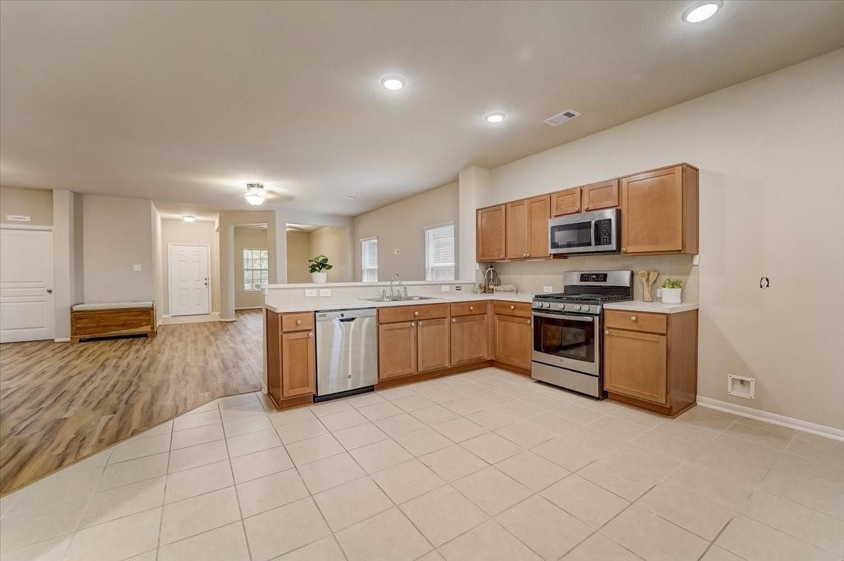 8827 Willet Street Baytown, TX 77521 - Photo 2 of 18 a kitchen with stainless steel appliances and white cabinets