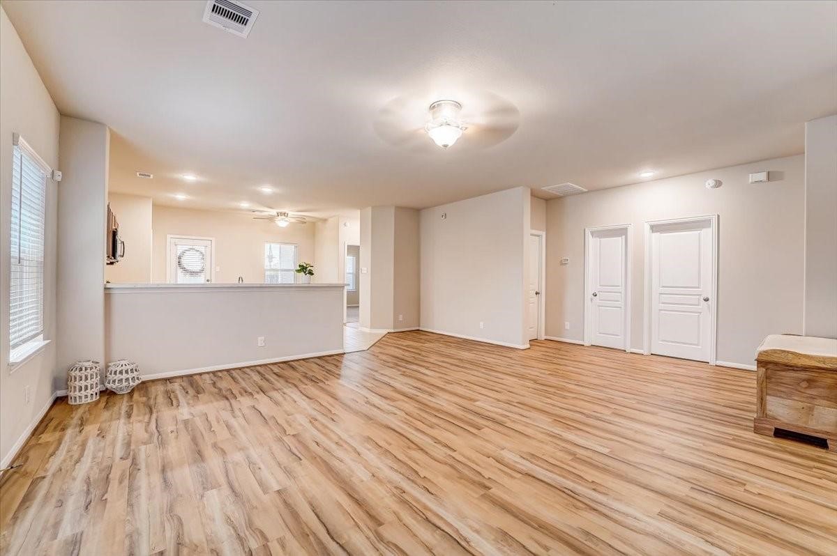 8827 Willet Street Baytown, TX 77521 - Photo 4 of 18 a view of an empty room with wooden floor and a window