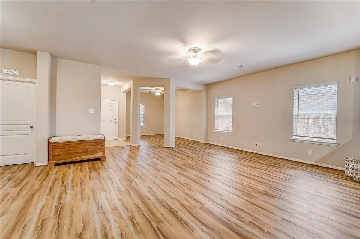 8827 Willet Street Baytown, TX 77521 - Photo 6 of 18 a view of empty room with wooden floor and fan