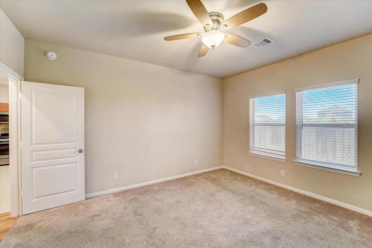 8827 Willet Street Baytown, TX 77521 - Photo 7 of 18 an empty room with windows and fan