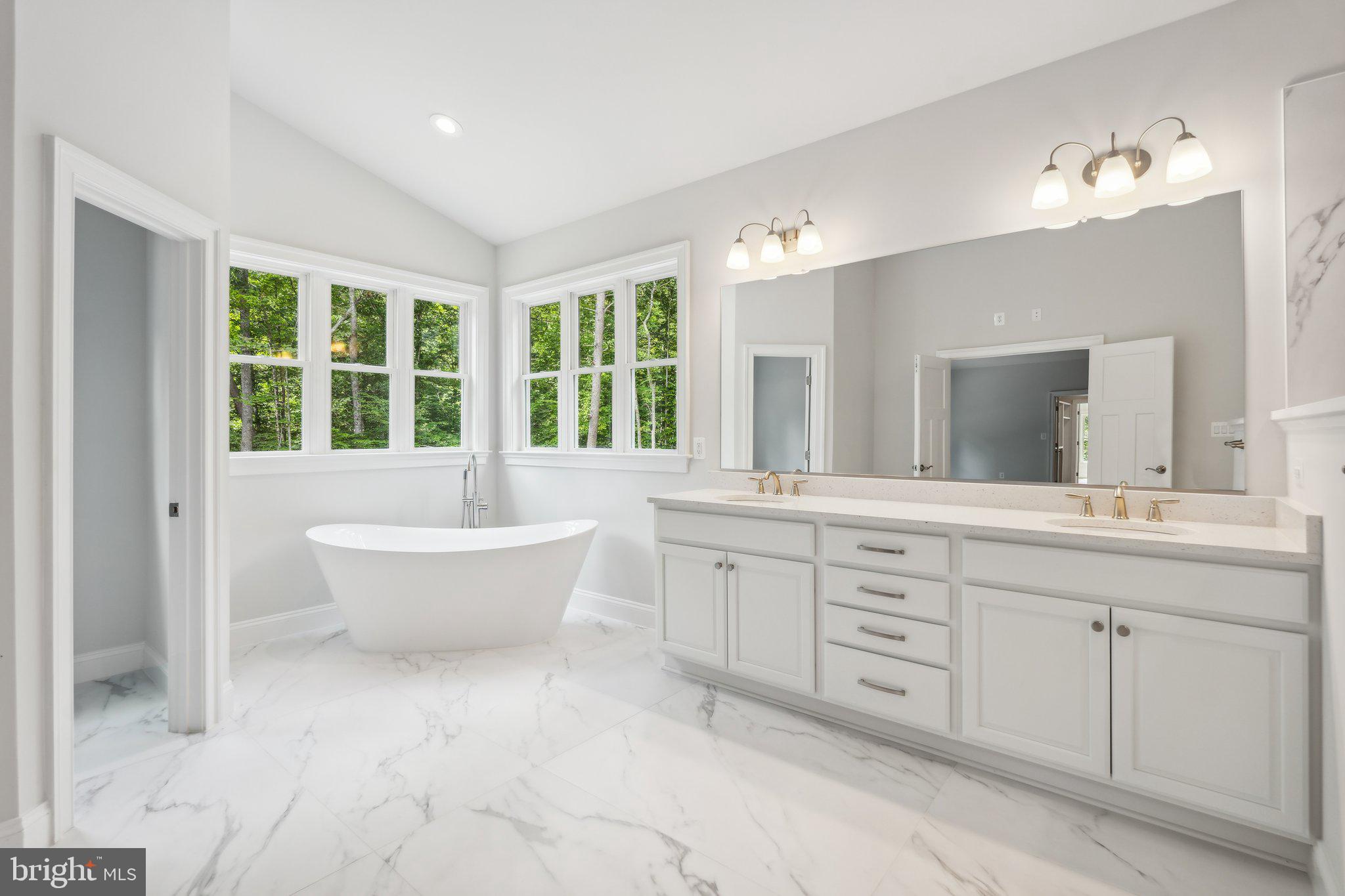 13749 Orlando Road Nokesville, VA 20181 - Photo 18 of 42 a spacious bathroom with a double vanity sink a large mirror and a bathtub