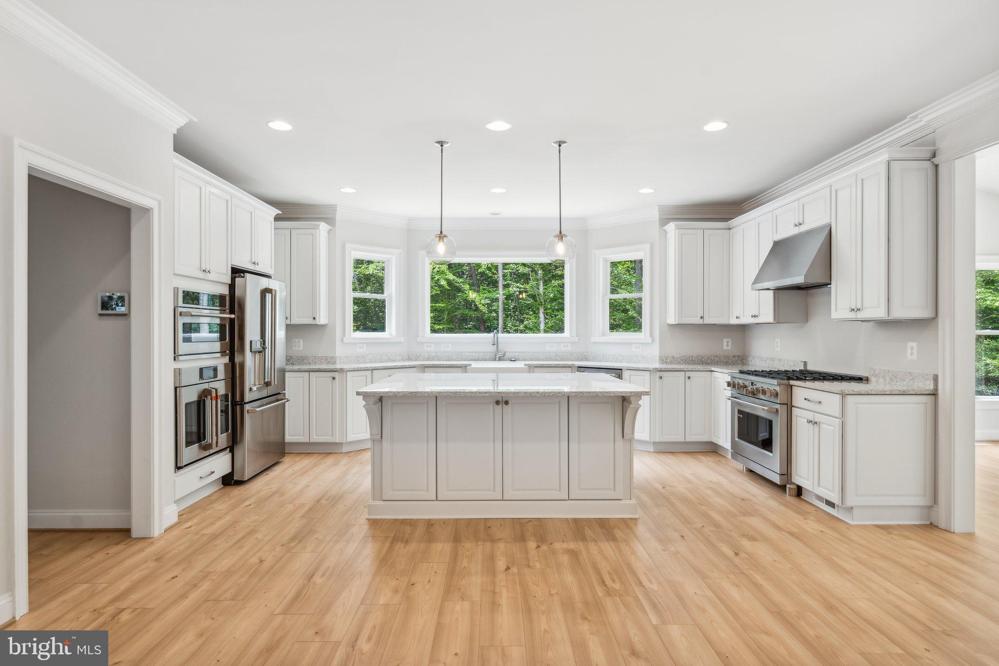 13749 Orlando Road Nokesville, VA 20181 - Photo 39 of 42 a kitchen with stainless steel appliances kitchen island granite countertop a stove a sink a refrigerator and white cabinets with wooden floor