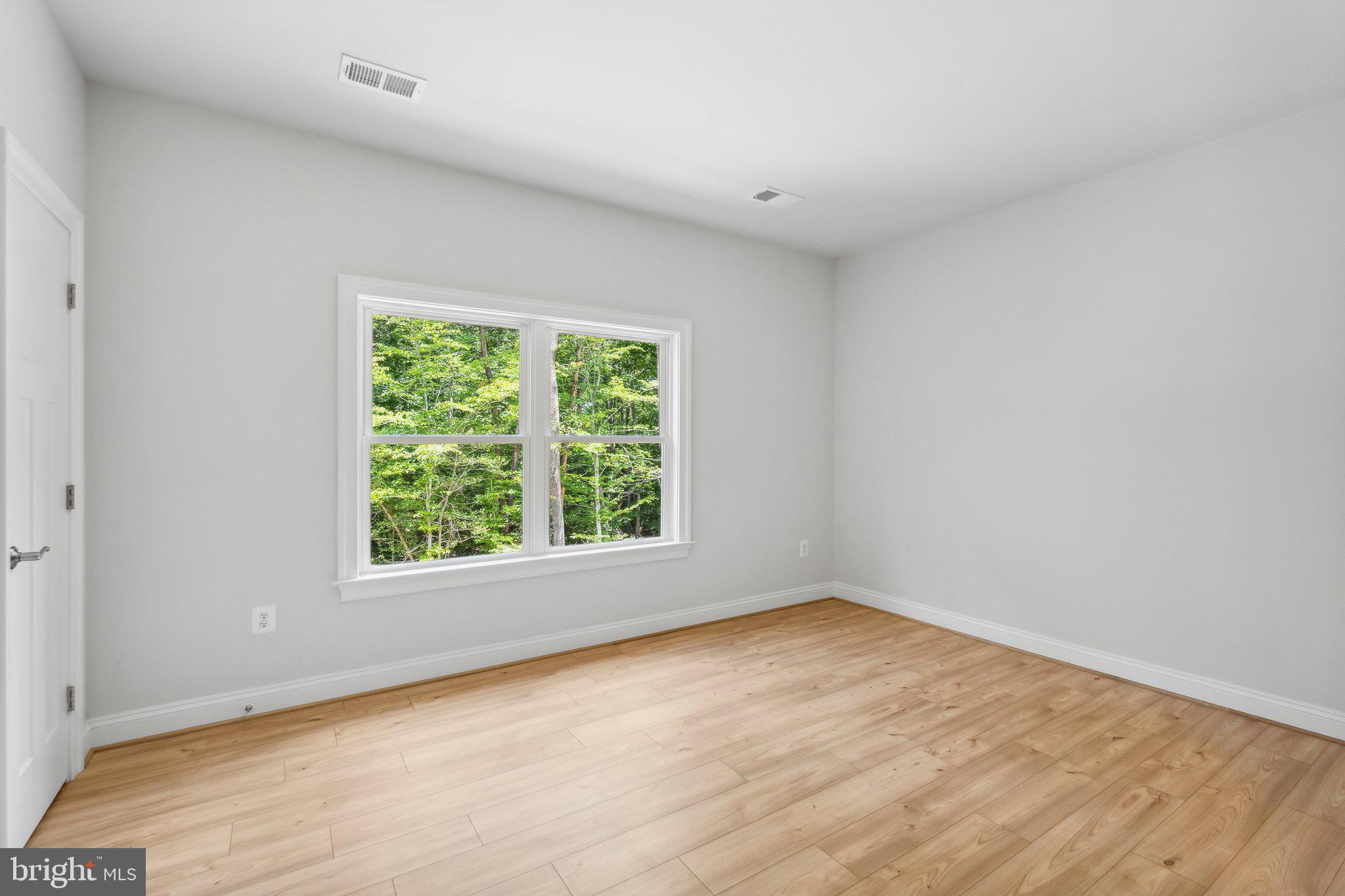 13749 Orlando Road Nokesville, VA 20181 - Photo 4 of 42 an empty room with wooden floor and windows