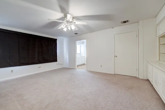 a view of an empty room with a ceiling fan