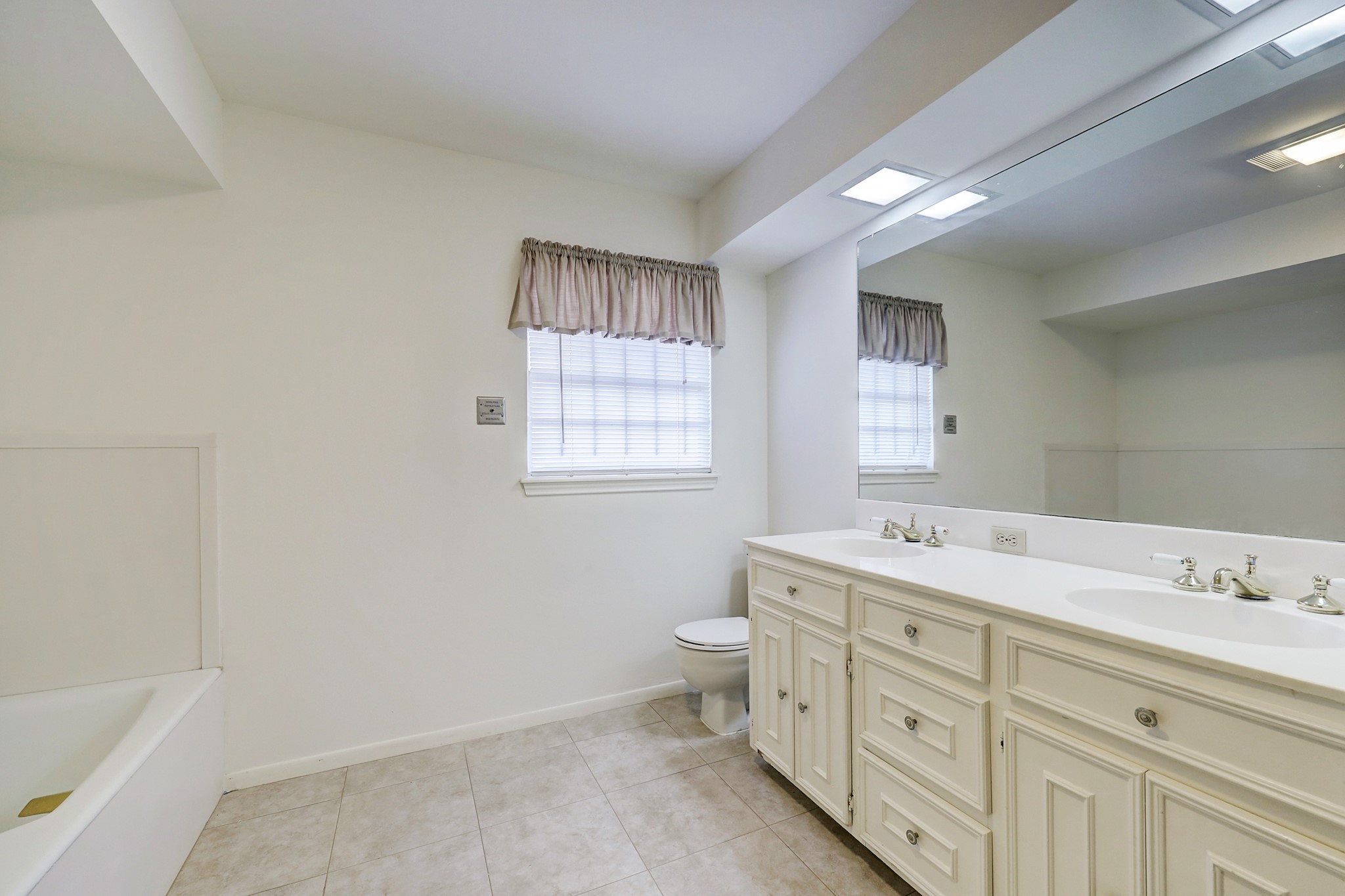 4002 Portsmouth Street Houston, TX 77027 - Photo 15 of 15 a spacious bathroom with double vanity sink a mirror and a toilet