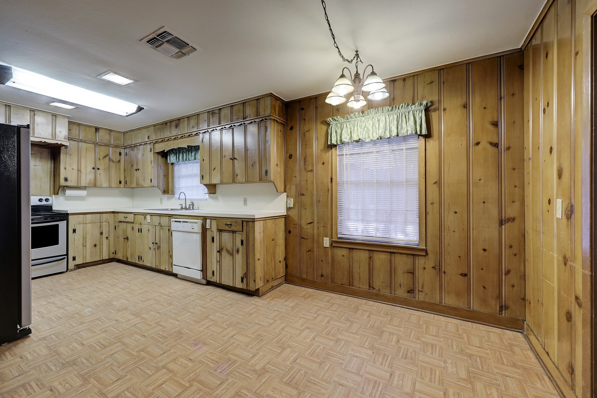 4002 Portsmouth Street Houston, TX 77027 - Photo 6 of 15 a kitchen with a chandelier a sink cabinets and stainless steel appliances