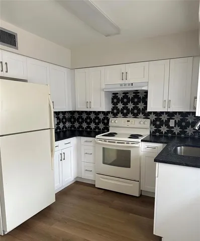 a white stove top oven sitting inside of a kitchen