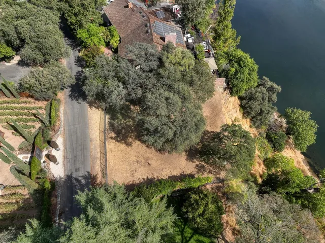 an aerial view of a house with a yard and lake view