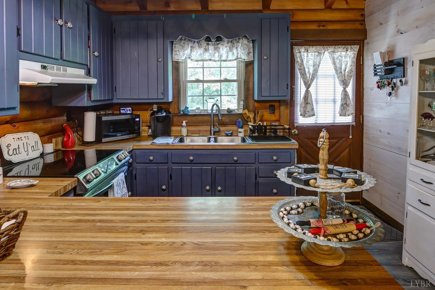 699 Gladys Road Gladys, VA 24554 - Photo 26 of 47 a kitchen with granite countertop wooden cabinets stainless steel appliances a stove and a window