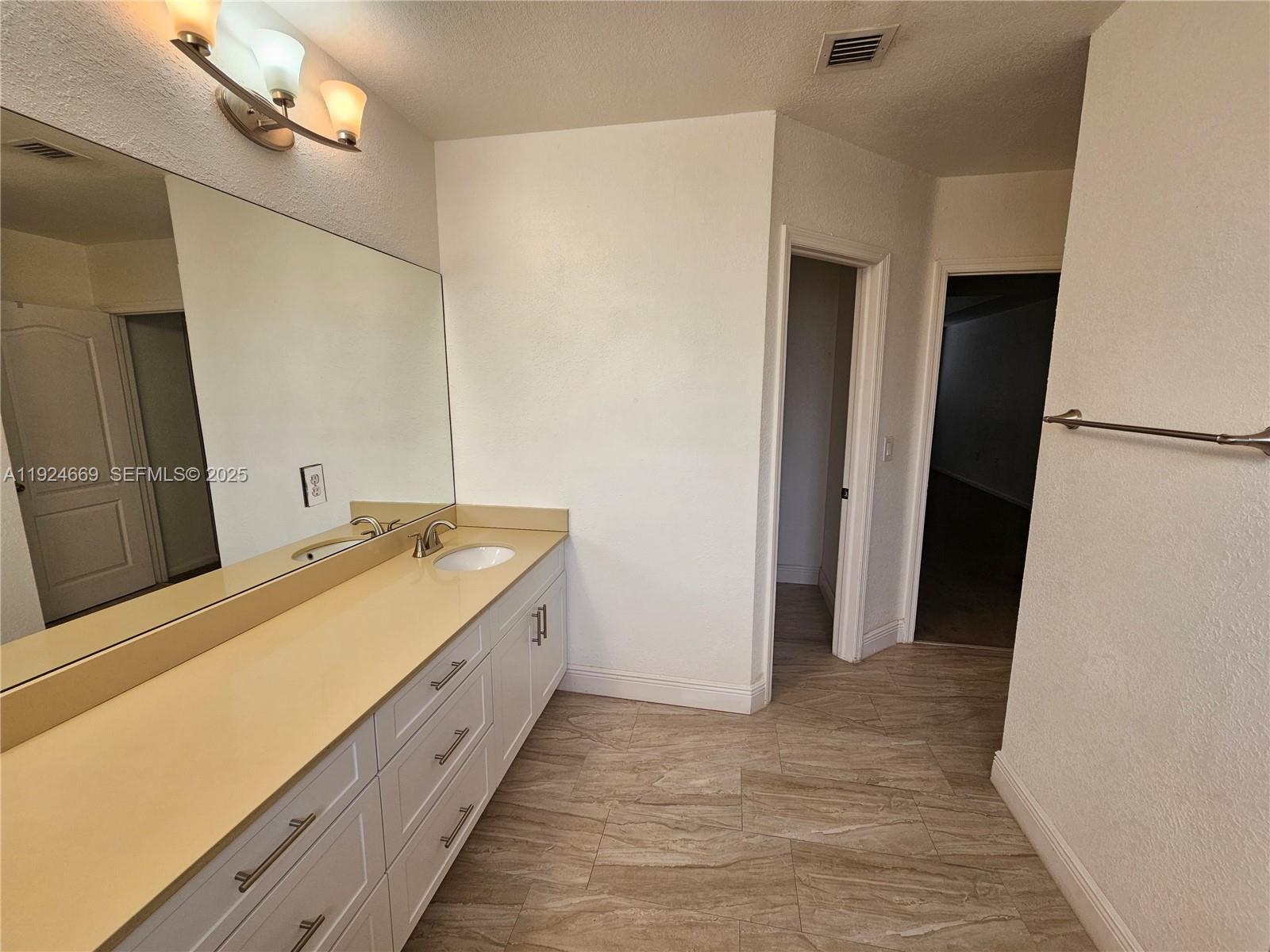 15447 Southwest 151st Street Miami, FL 33196 - Photo 13 of 25 a bathroom with a double vanity sink and a mirror