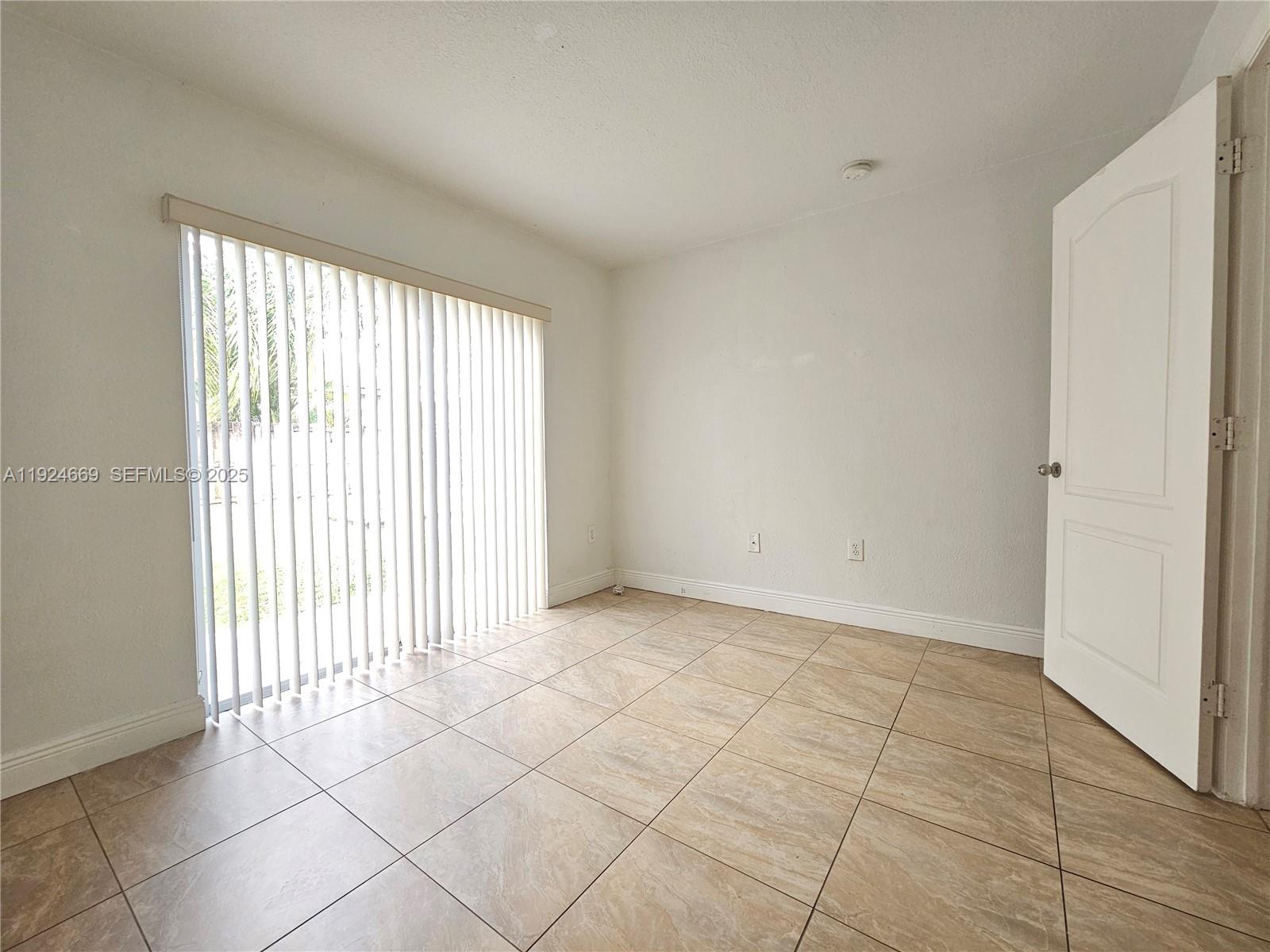 15447 Southwest 151st Street Miami, FL 33196 - Photo 7 of 25 a view of an empty room with a window