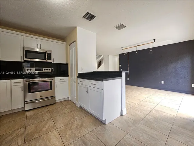 a kitchen with stainless steel appliances a stove sink and microwave