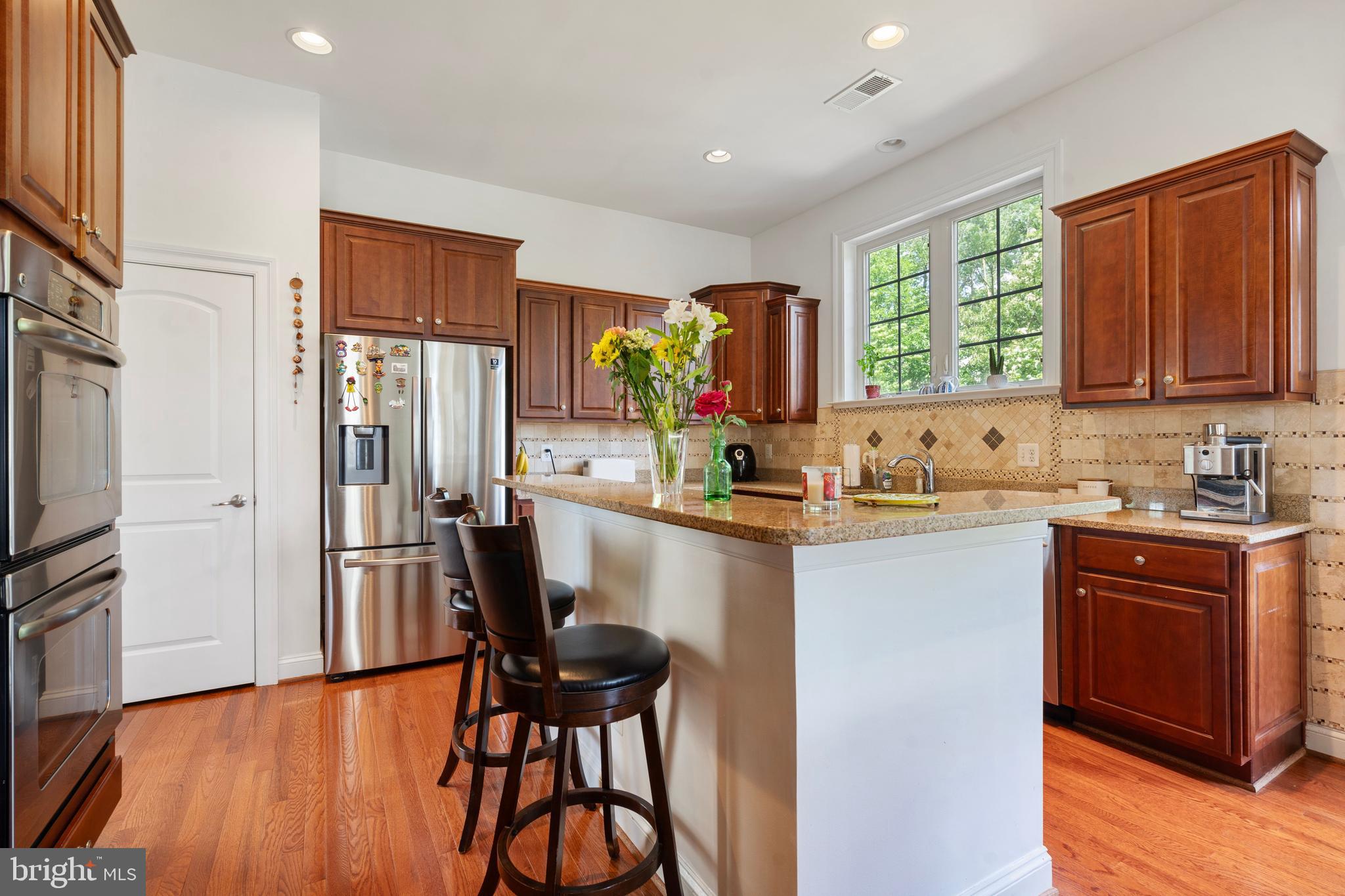 42735 Macauley Place Ashburn, VA 20148 - Photo 12 of 39 a kitchen with stainless steel appliances granite countertop a refrigerator a sink dishwasher a stove with wooden cabinets and wooden floor