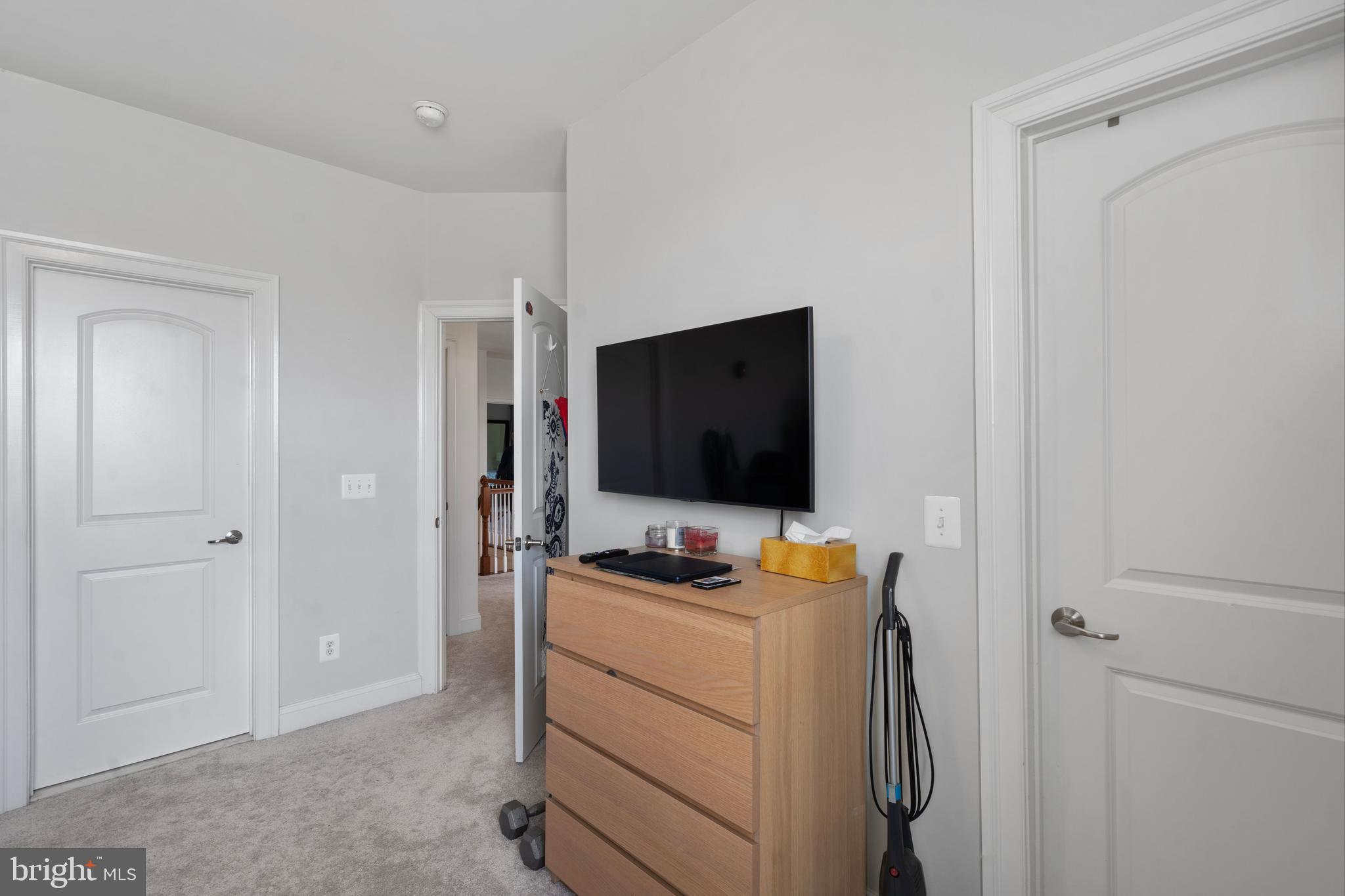 42735 Macauley Place Ashburn, VA 20148 - Photo 25 of 39 a bedroom with a bed and a flat screen tv