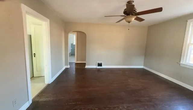an empty room with windows and fan