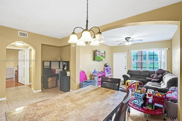 a view of a dining room with furniture and a chandelier