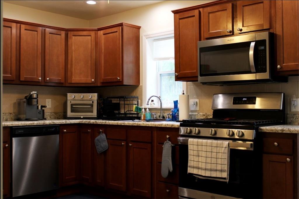 157 East College Street Canonsburg, PA 15317 - Photo 4 of 25 a kitchen with stainless steel appliances wooden cabinets a stove a microwave and a sink