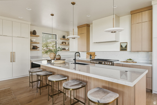 923 North Emery Lane Elk Ridge, UT 84651 - Photo 12 of 101 Spacious kitchen featuring an extended island with a light-toned countertop, a built-in range, and a white tile backsplash