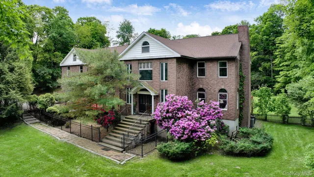 a front view of a house with a yard and potted plants