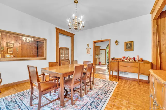 a view of a dining room with furniture a chandelier and wooden floor