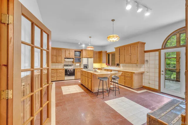 a large white kitchen with a large window and stainless steel appliances