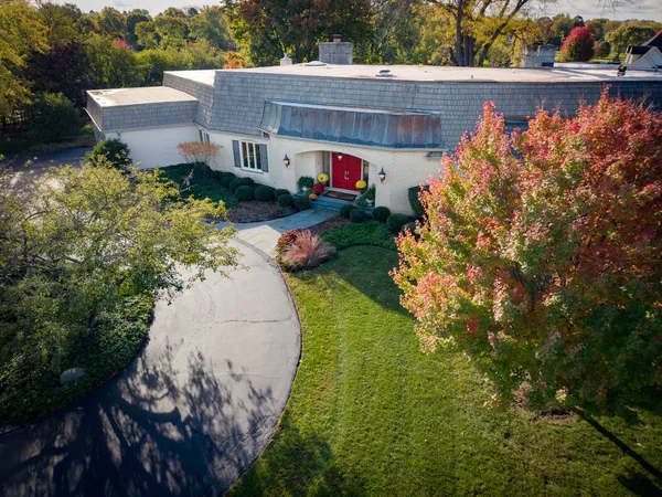 a aerial view of a house with a yard and a large tree